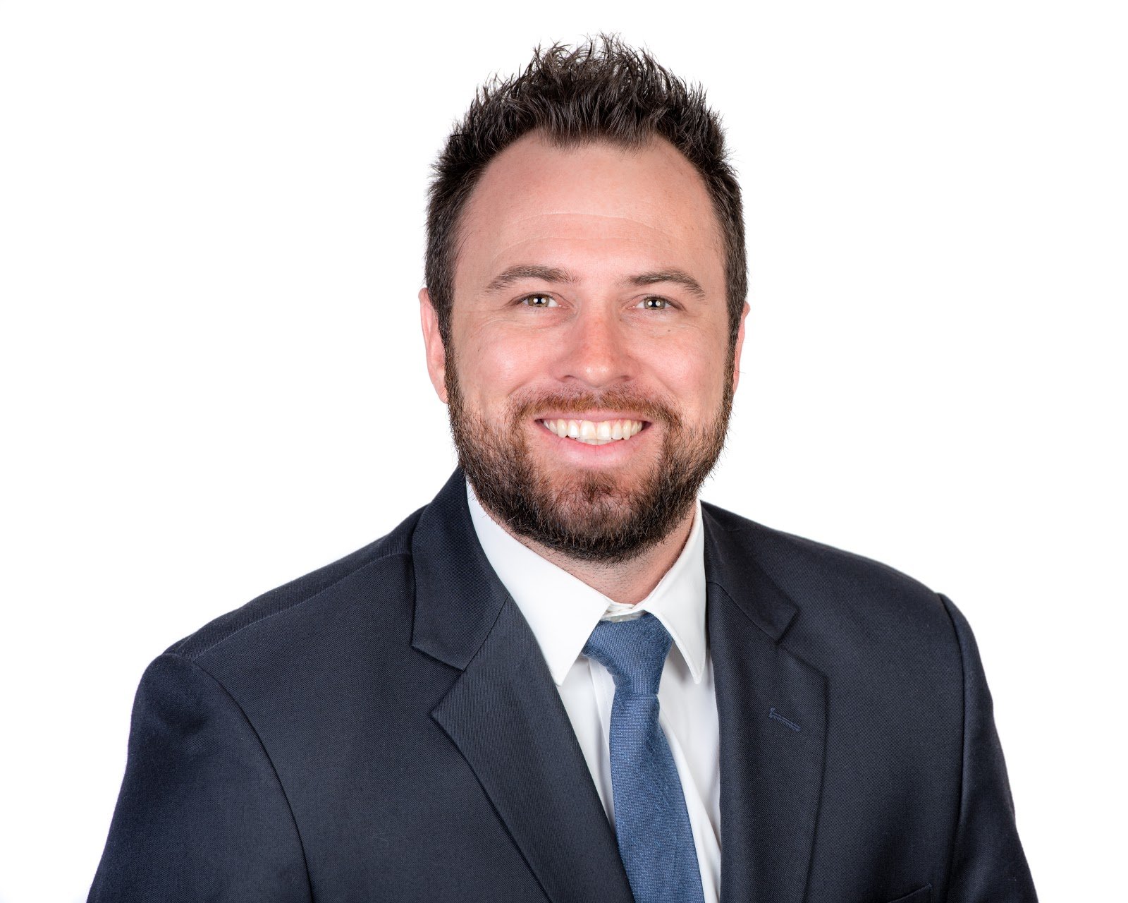Professional business headshot — man in navy suit, white background